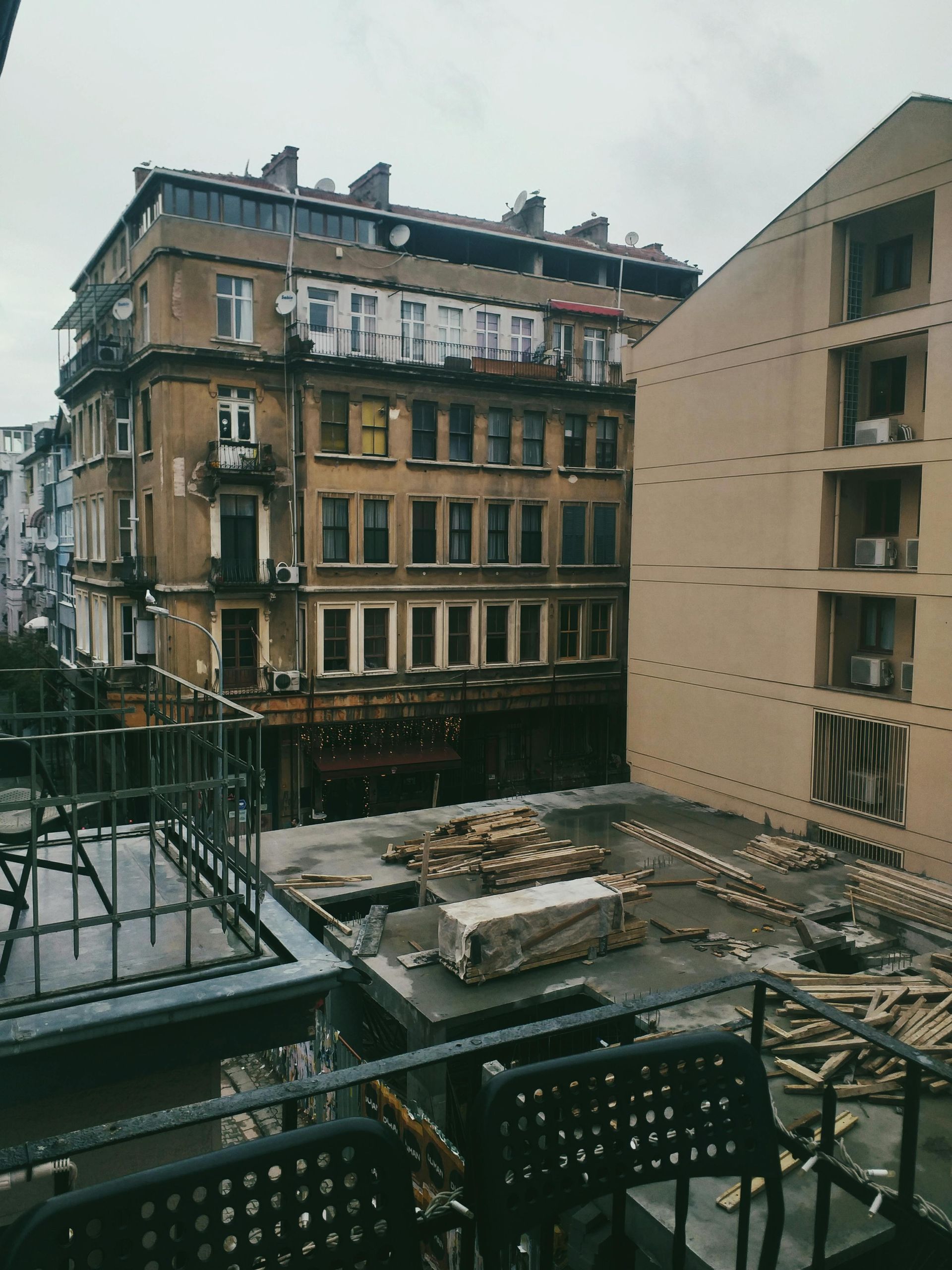 A balcony with a view of a building under construction