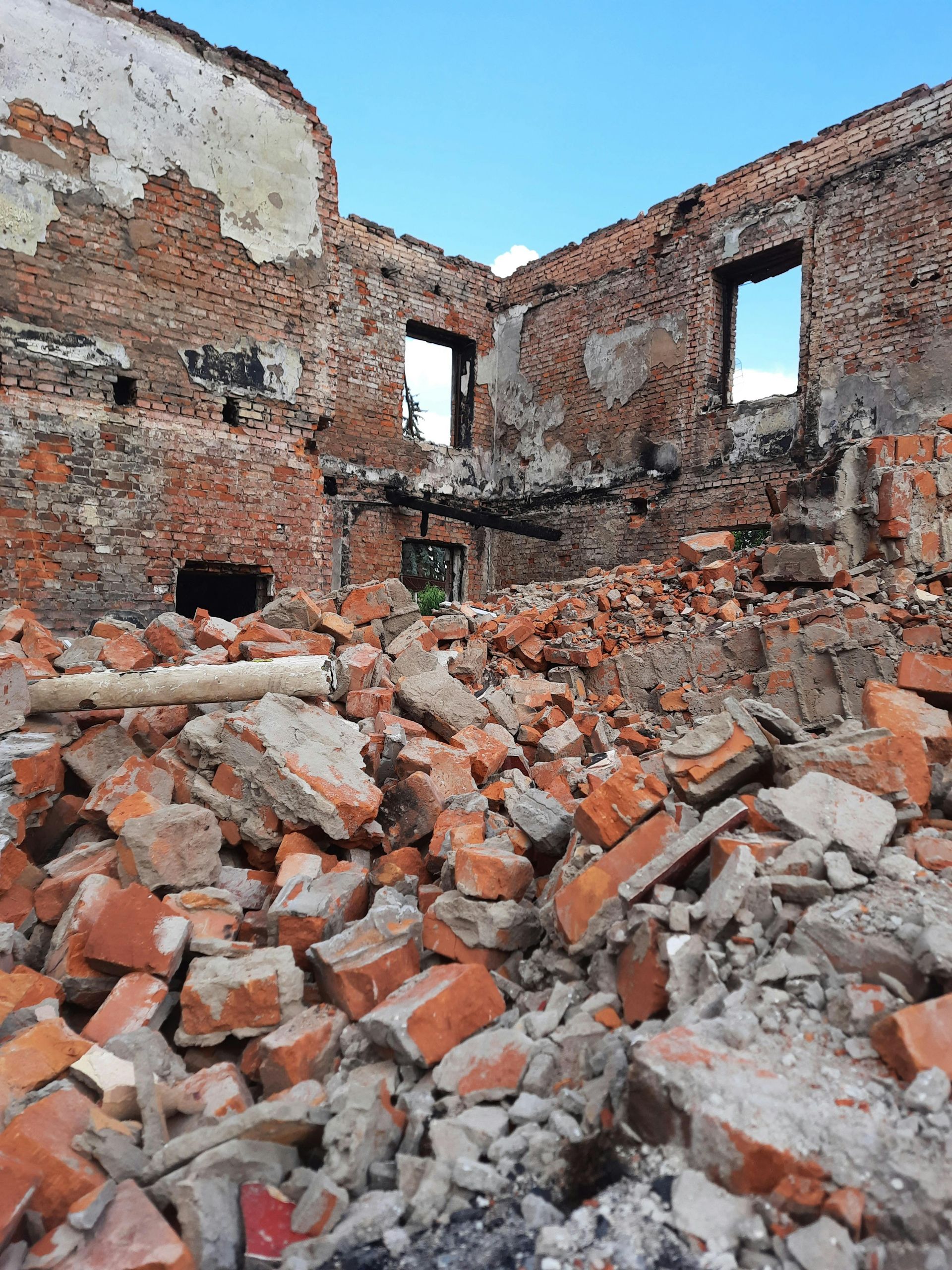 A pile of bricks and rocks in front of a brick building.
