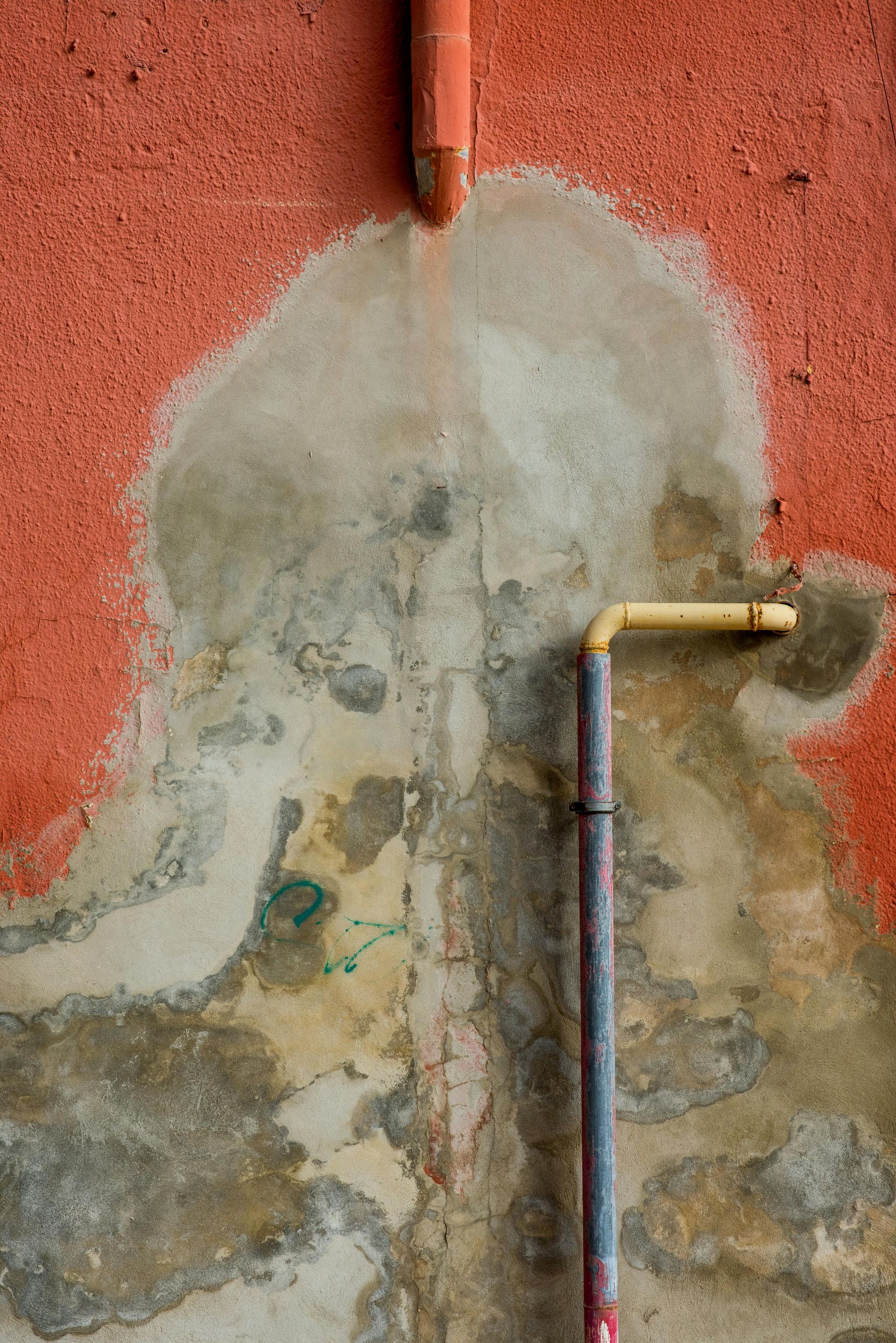 A close up of a pipe on a red wall.