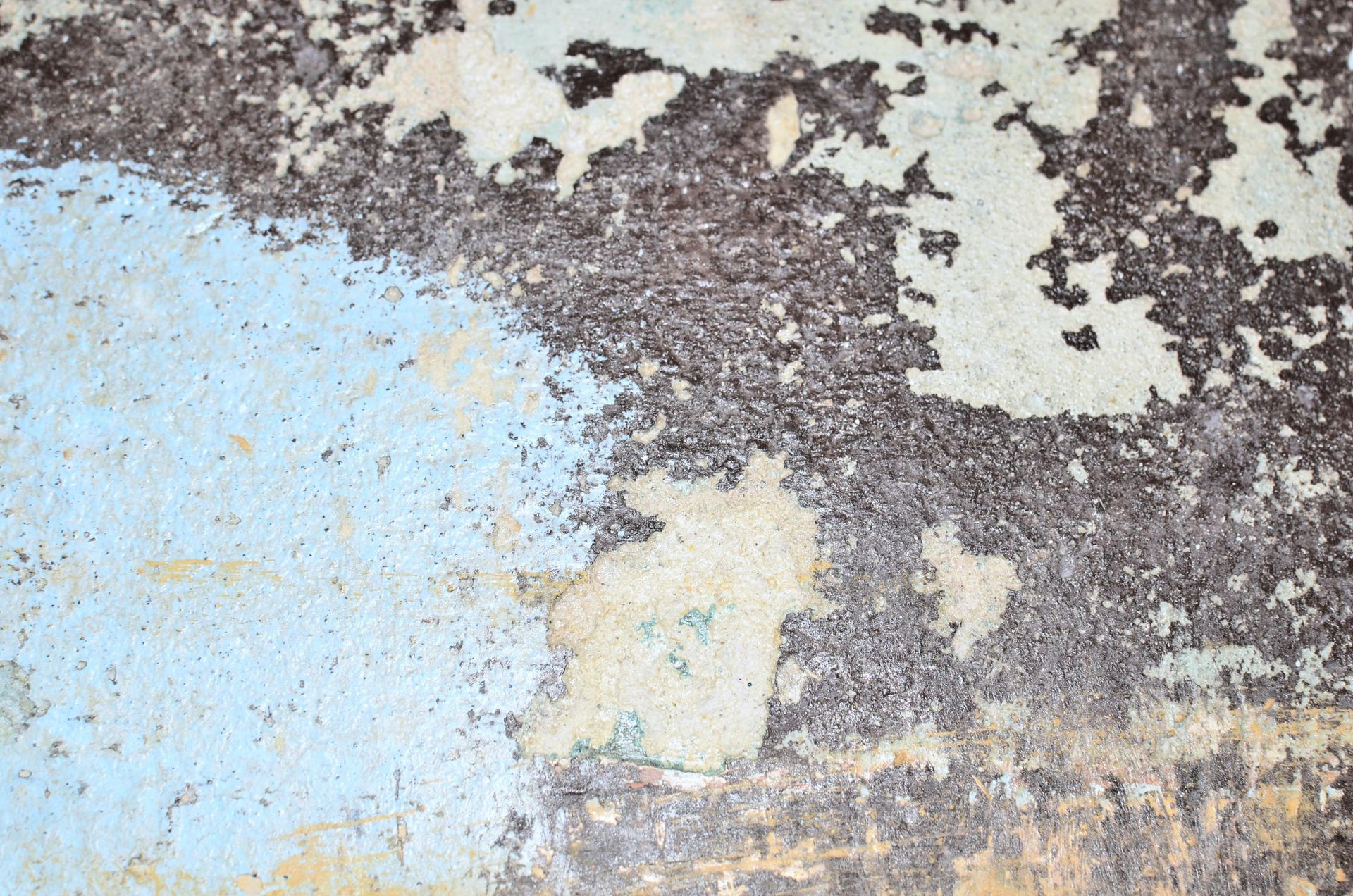 A close up of a wall with peeling paint on it