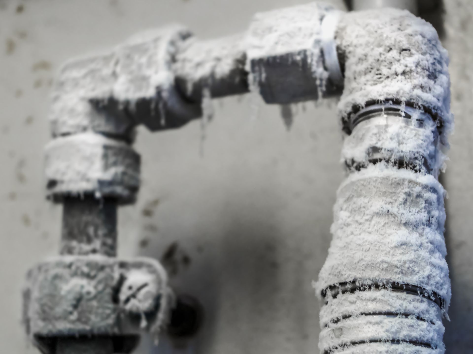 Close-up view of icy pipes, representing the need of reliable plumber services in cold weather.