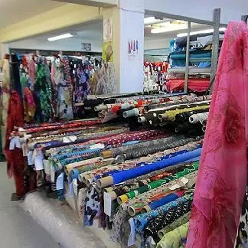 Fabric rolls in a fabric store, with colorful patterns and fabrics on display.