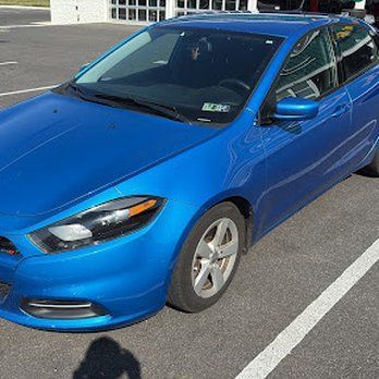 Blue Dodge Dart parked on pavement.
