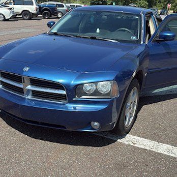 Blue Dodge Charger parked in a parking lot with door open.
