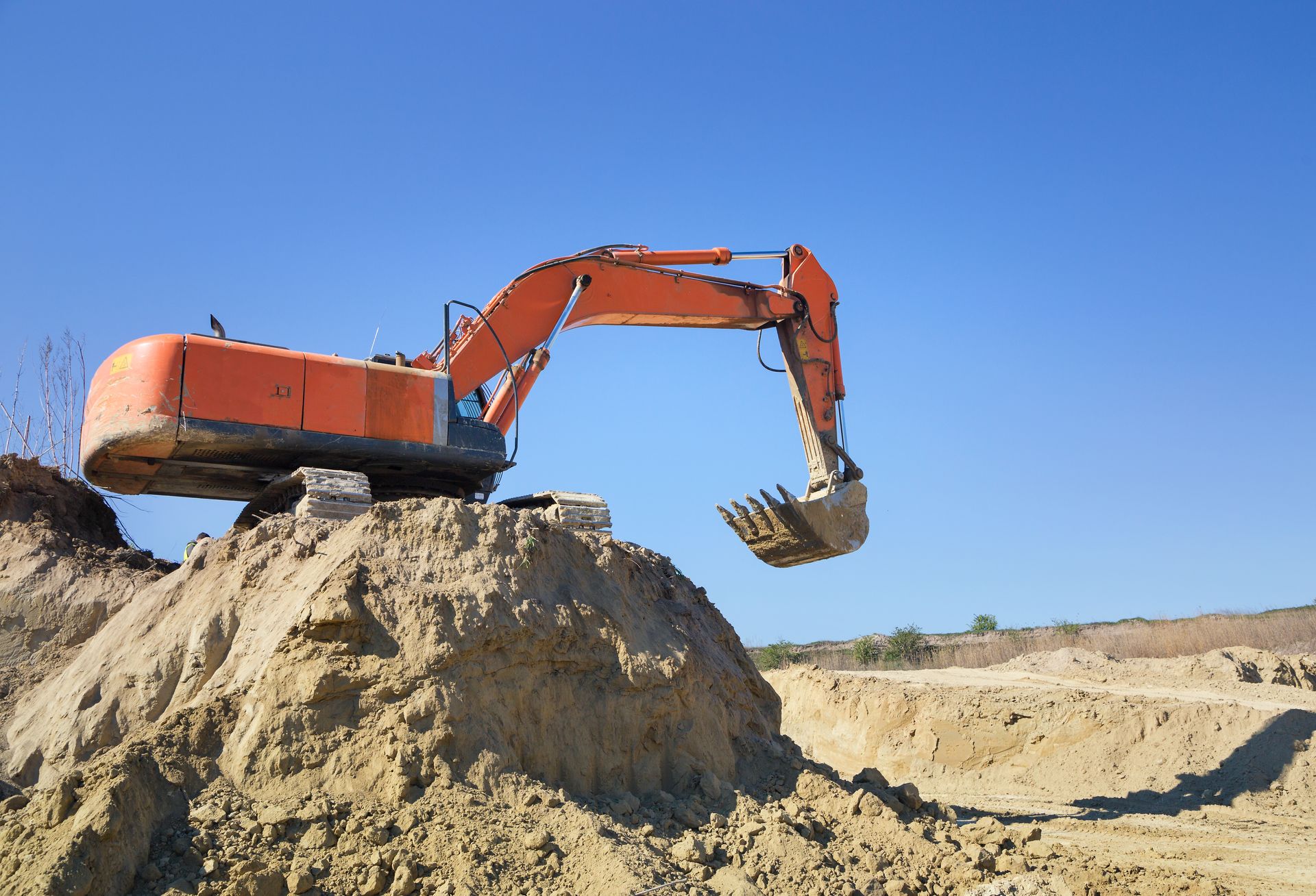 Huge crawler excavator and a construction dump truck at work on sand quarry.