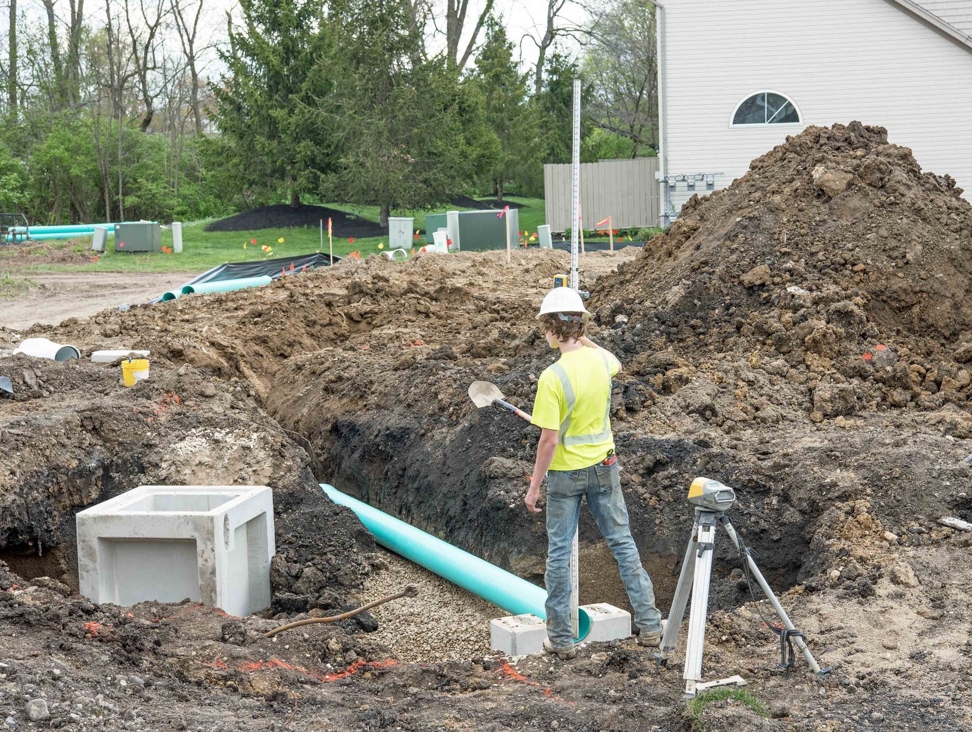 Utility trench excavation with the contractor installing underground PVC piping.