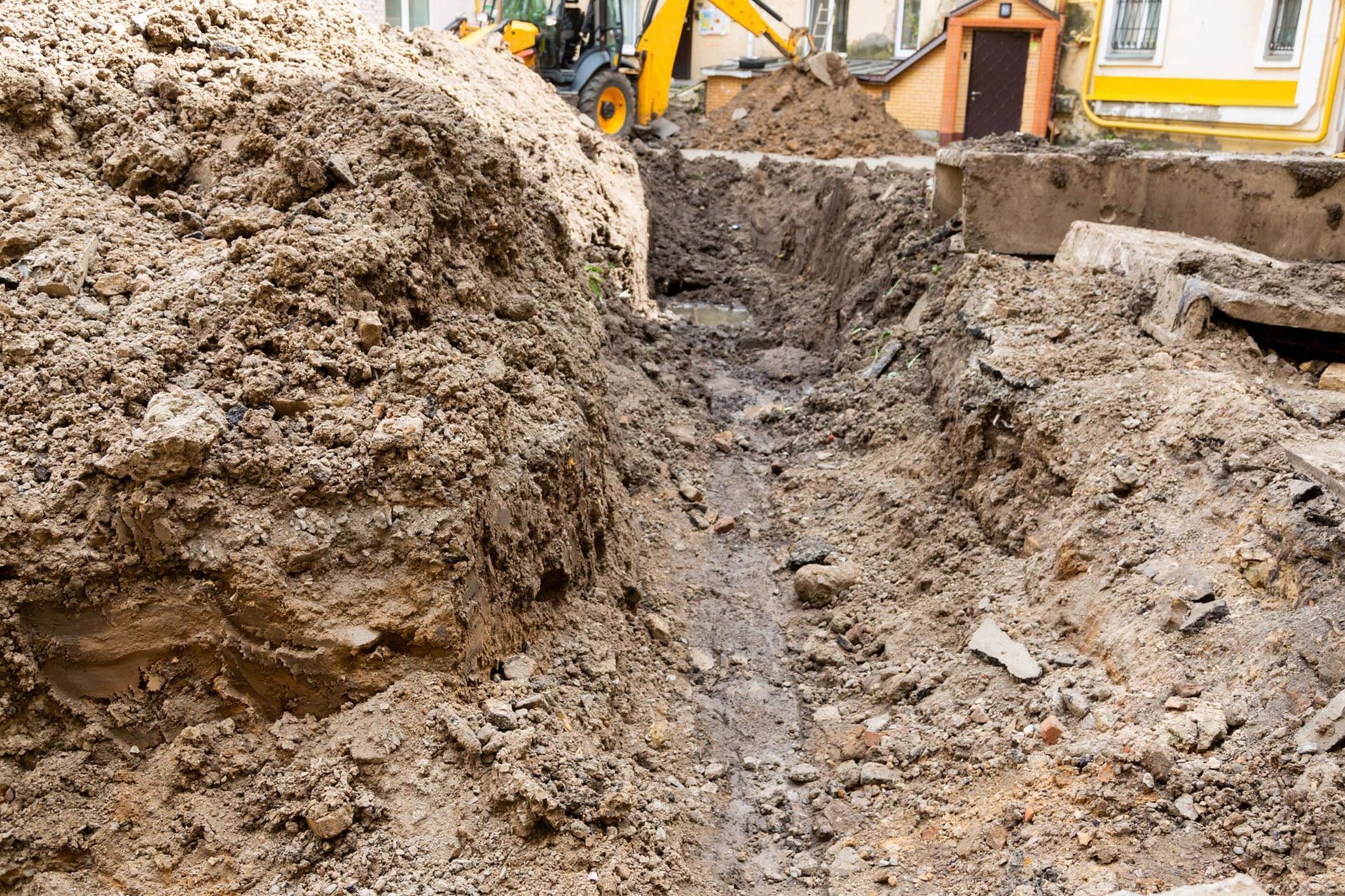 A large pile of dirt is being excavated by a bulldozer.