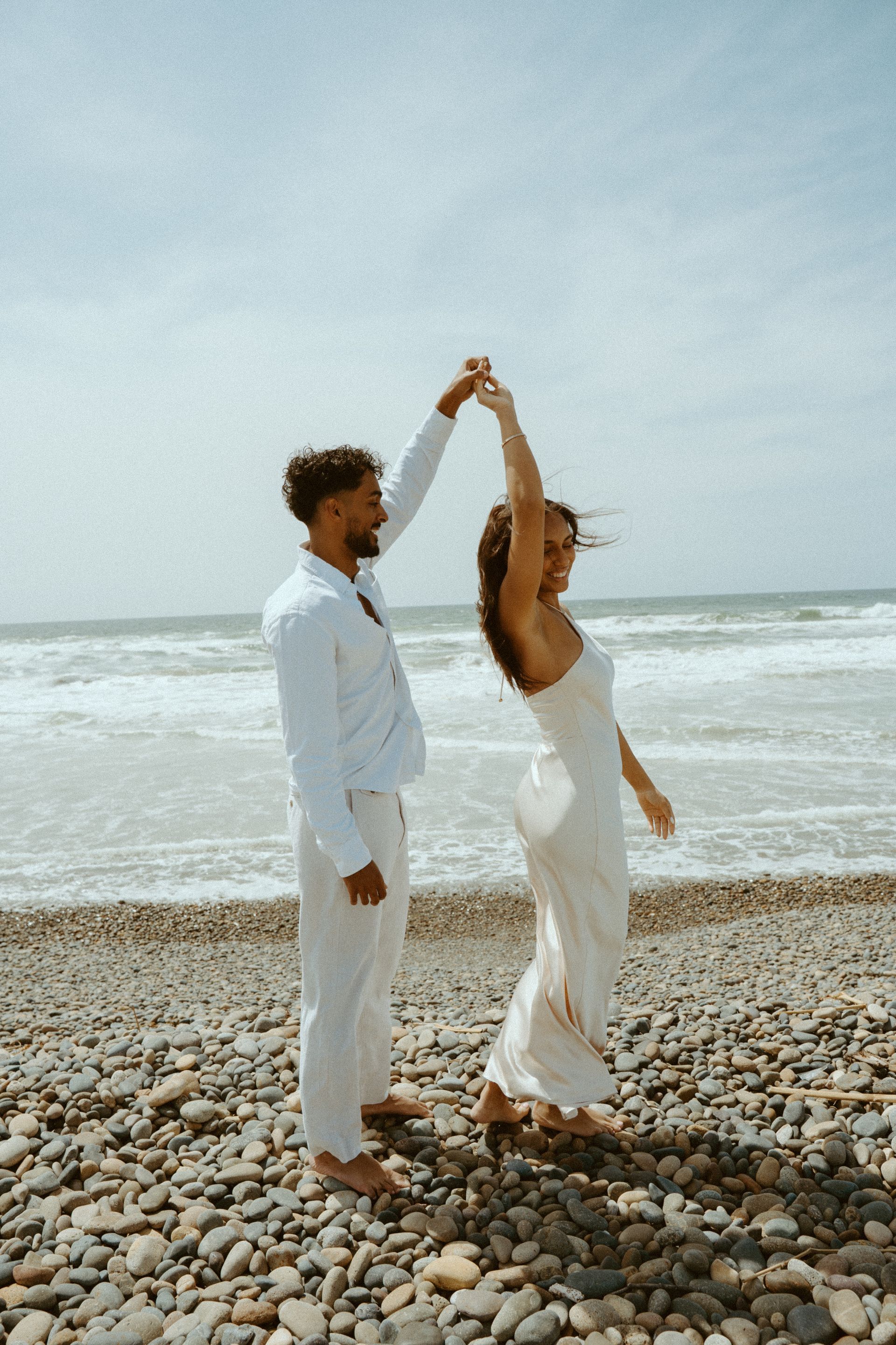 A bride and groom are holding hands and looking at each other.