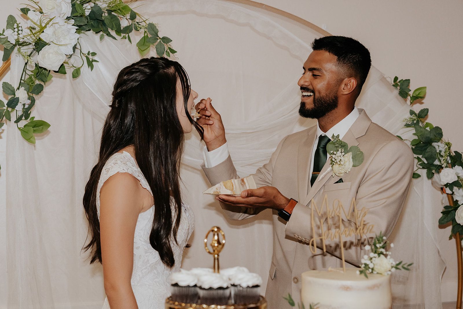 Groom feeding his wife with a cake.