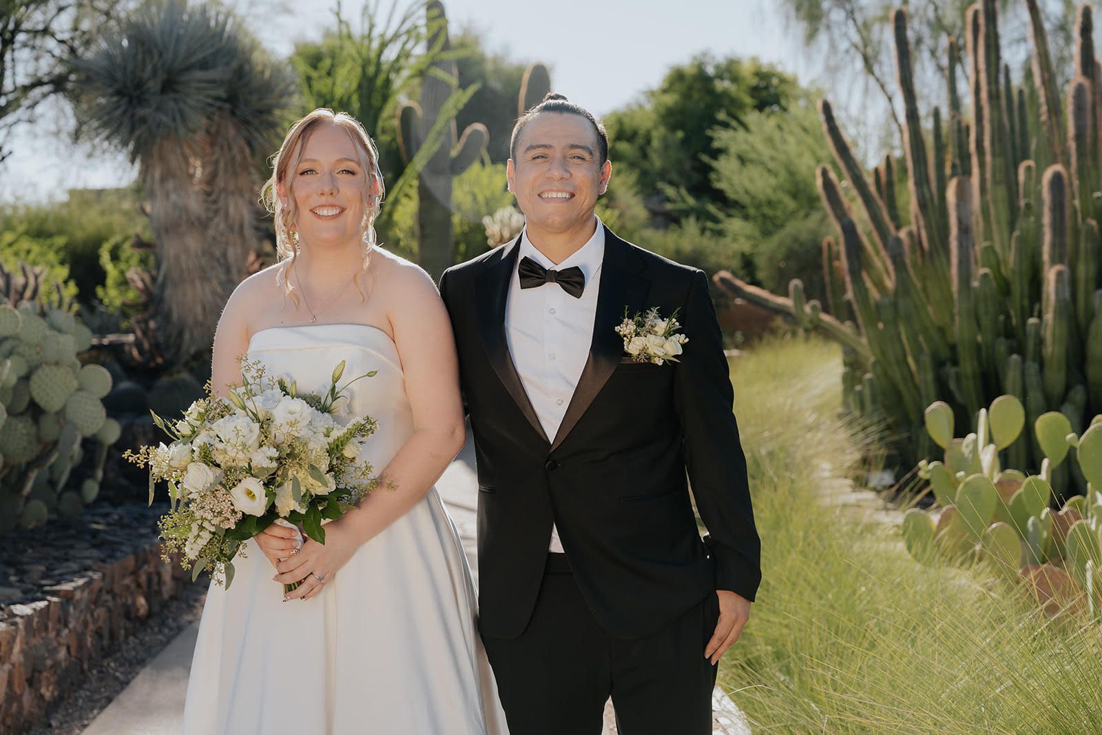 Bride and groom sharing a romantic kiss during their wedding dance at night under string lights.