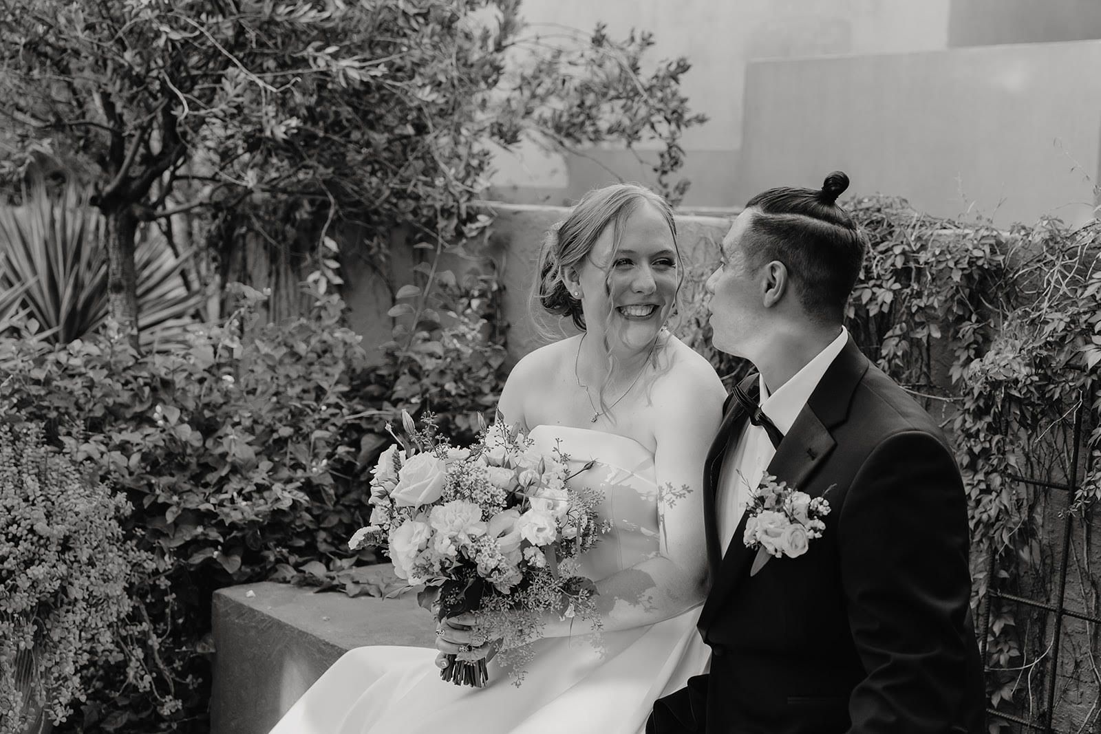 Bride and groom sharing a romantic kiss during their wedding dance at night under string lights.