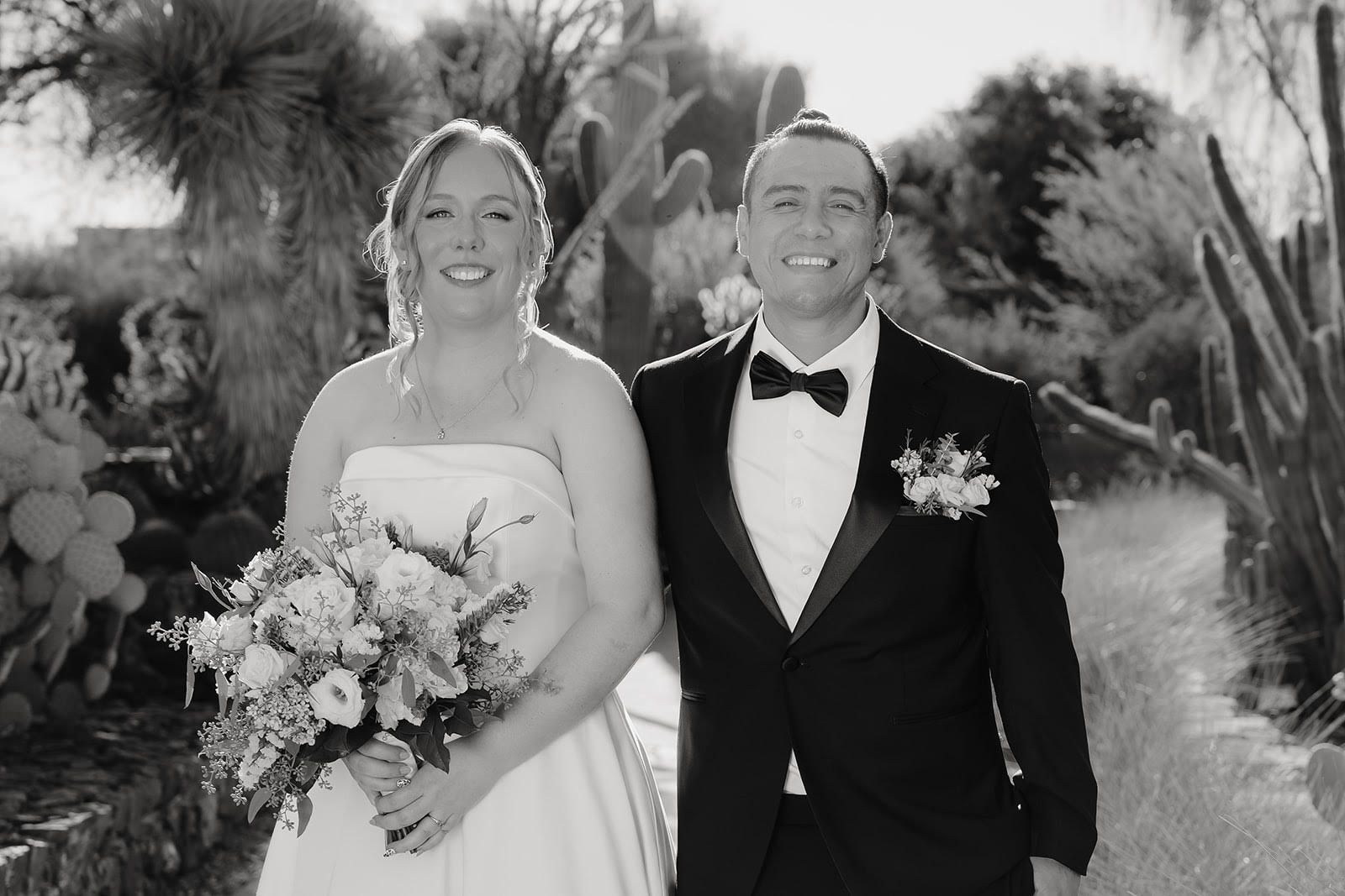 Bride and groom sharing a romantic kiss during their wedding dance at night under string lights.
