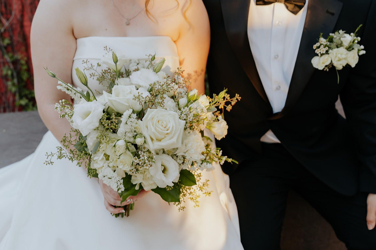 Bride and groom sharing a romantic kiss during their wedding dance at night under string lights.