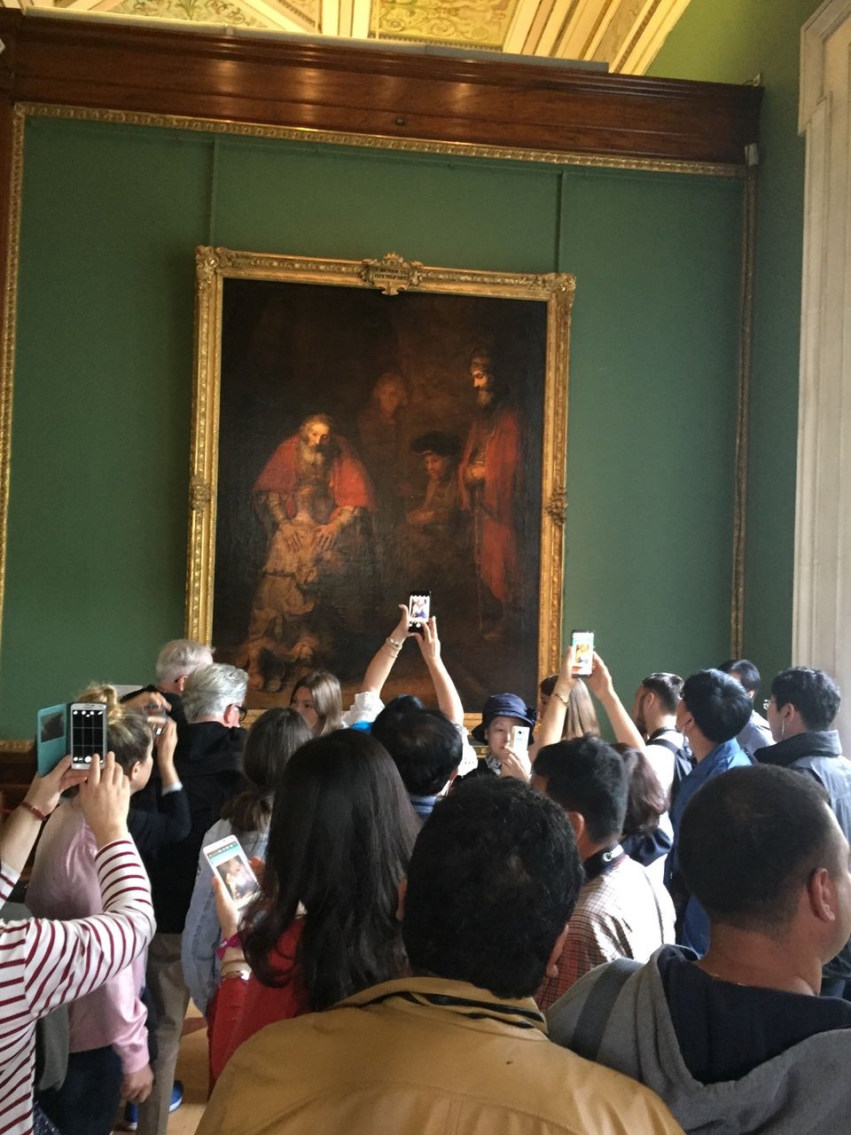 groep toeristen maakt foto van rembrandt in hermitage
