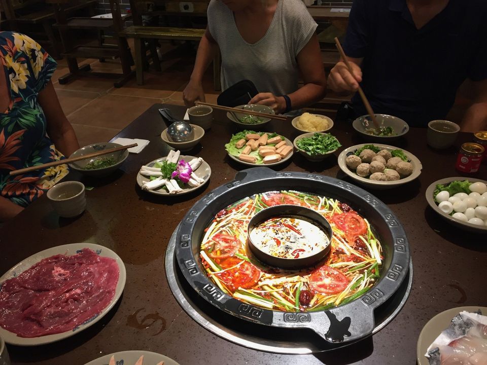 grote ronde tafel met daarop hotpotgerechten