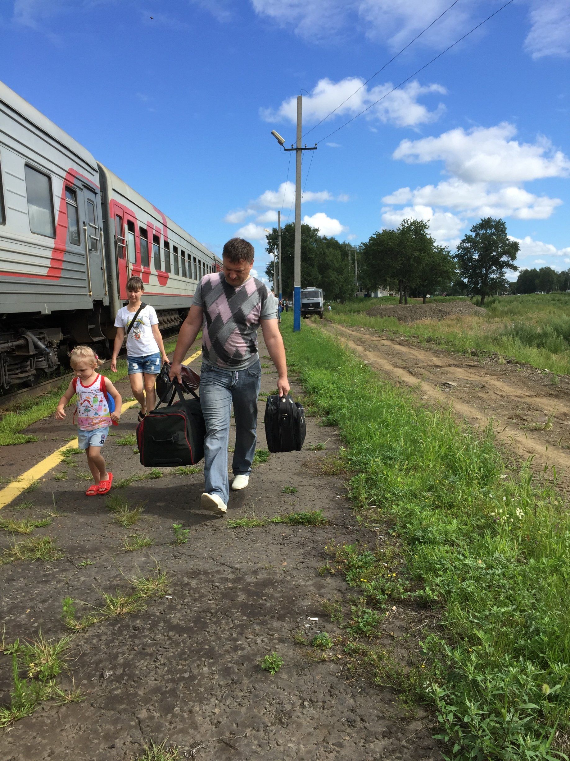 man loopt met kind langs trein rusland