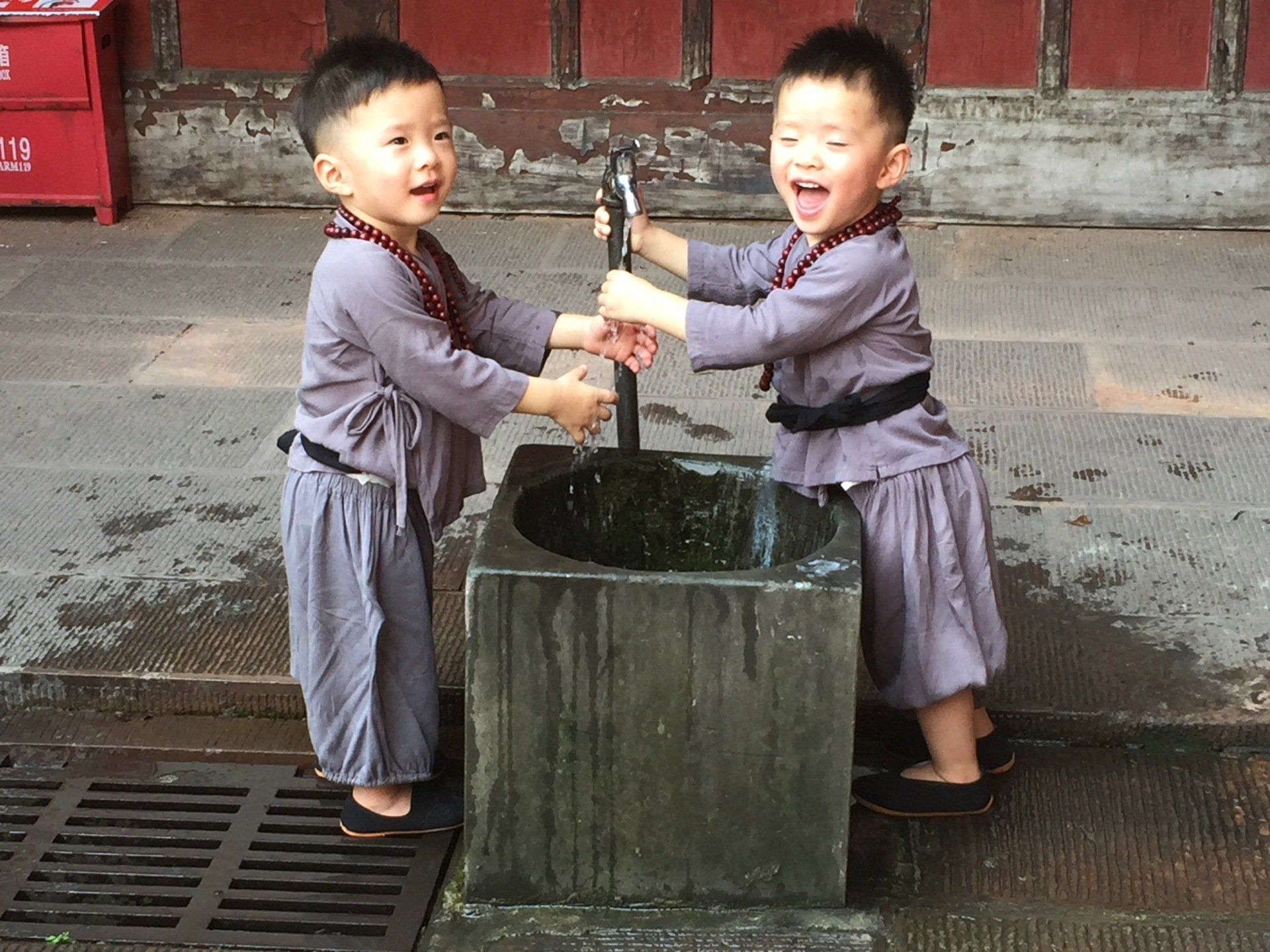 chinese tweeling speelt met waterkraan