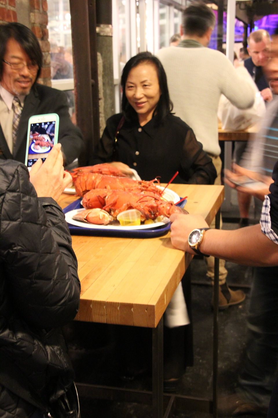 Aziaten eten staand hele kreeft in Chelsea Market