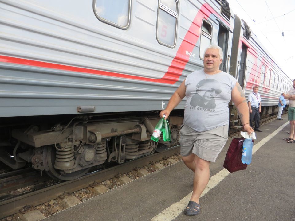 rus met t-shirt van Poetin loopt langs trein