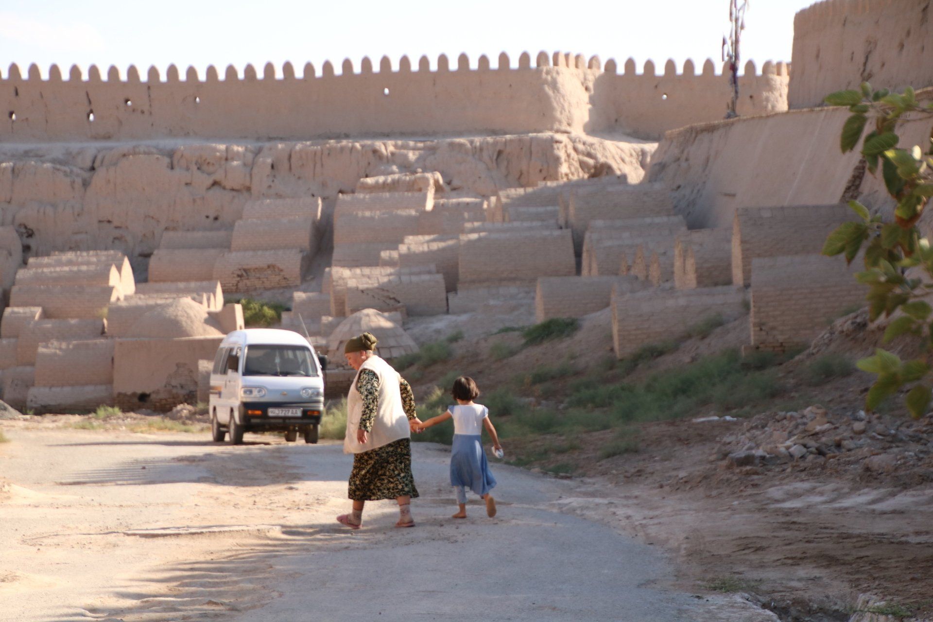 oma en kind door achterafstraatje van Khiva