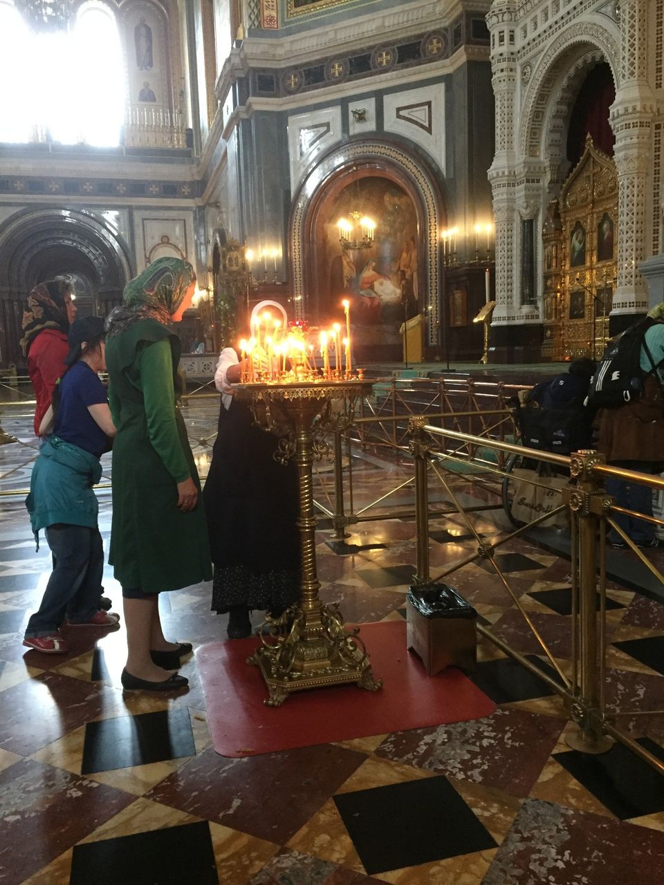 vrouwen in russische kerk steken kaarsen aan 