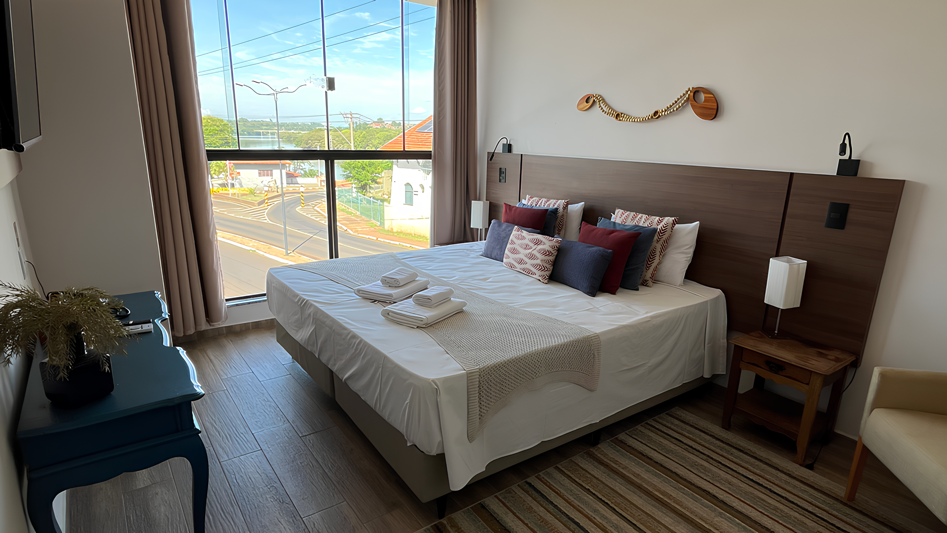 Há uma cama grande no meio do quarto. Hotel Barra Bonita