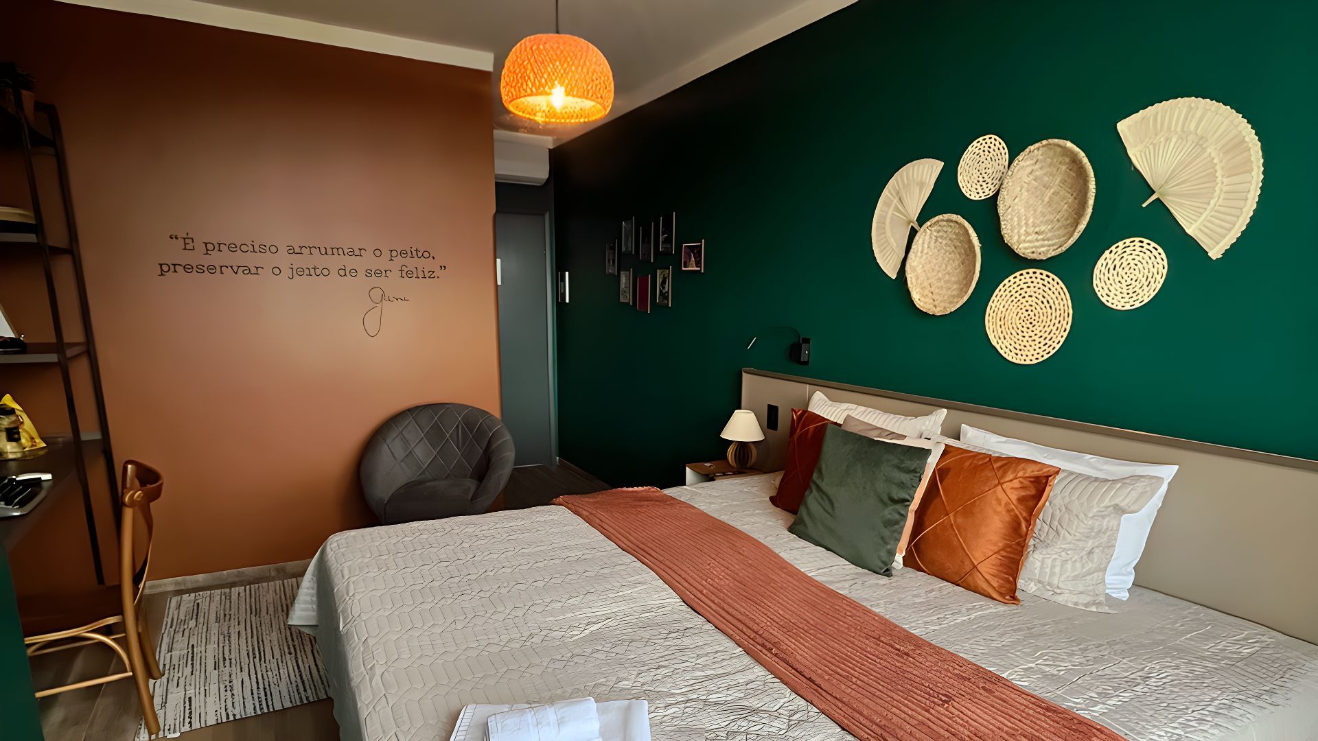 Um quarto com uma cama, cadeira, escrivaninha e paredes verdes. Hotel Barra Bonita