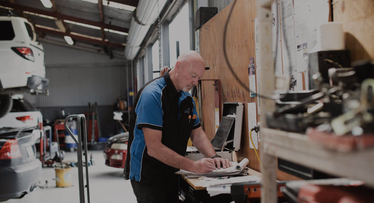 A tradesman filling out paperwork in his workshop