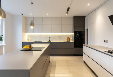 Modern kitchen with gray cabinetry, white countertops, island, built-in appliances, and pendant lights.
