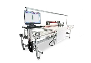 A computer is sitting on top of a table next to a machine.