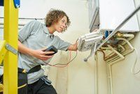 Commercial Electrical Service — Female Electrician Checking Electric Connection in Mobile, Alabama