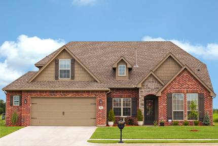 A large brick house with a tan garage door