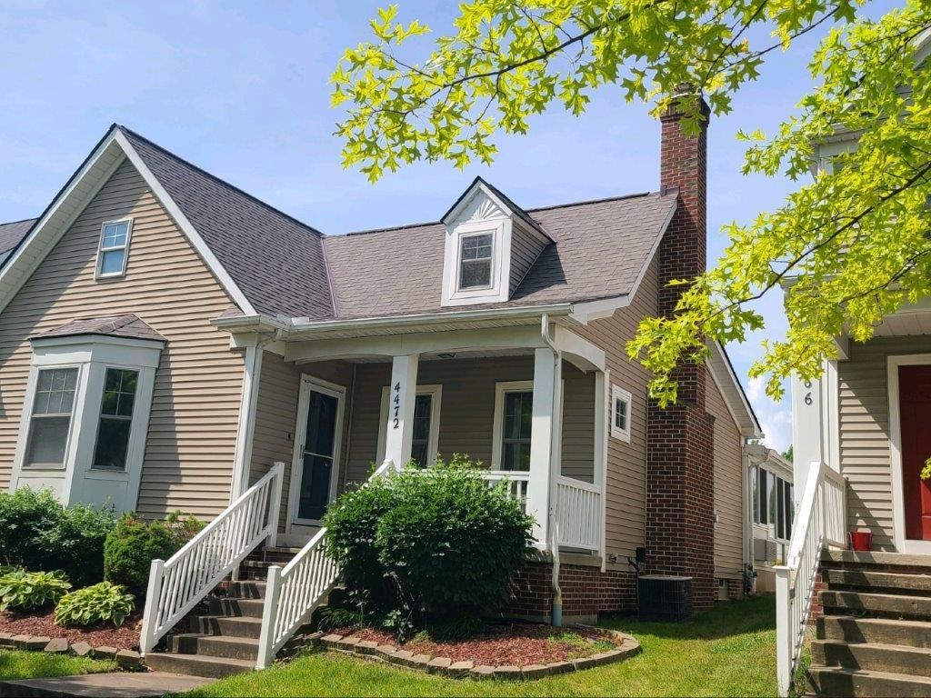A house with a porch and stairs in front of it