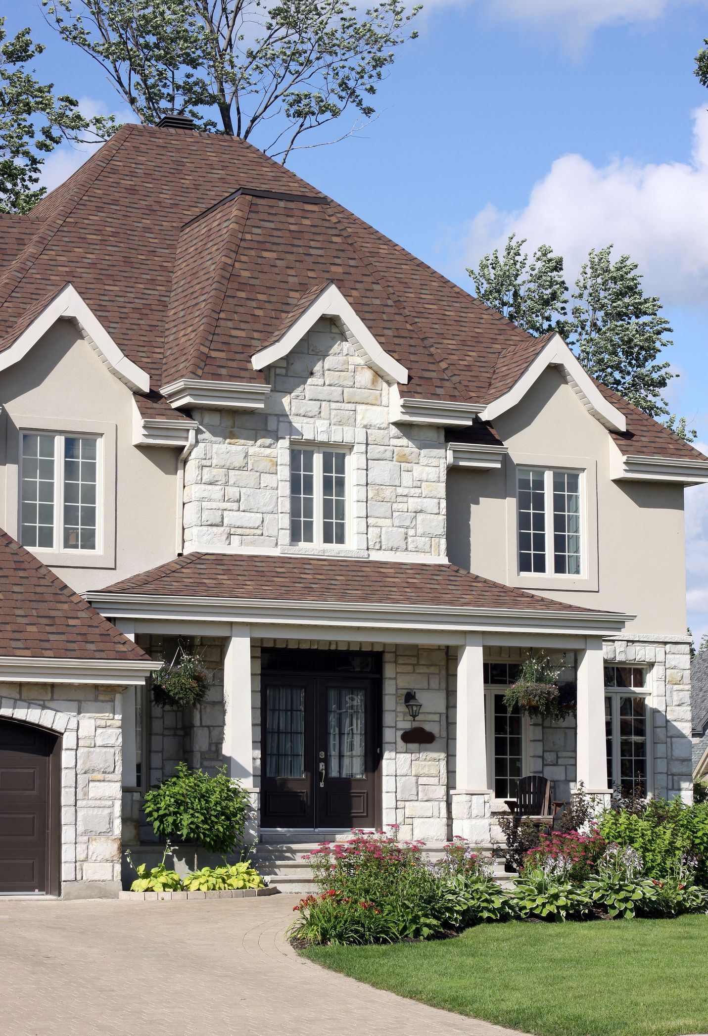 A brick house with a brown roof and a chimney on the roof.
