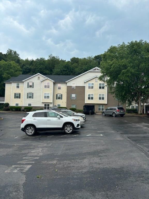 A white suv is parked in a parking lot in front of a building.