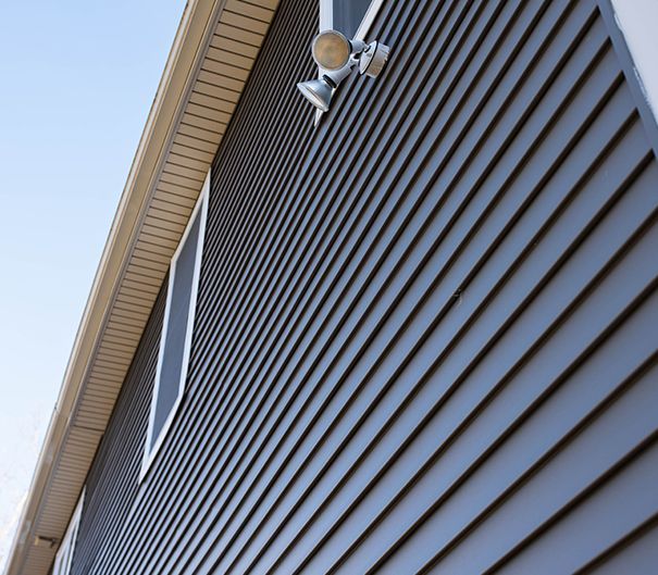 A house with a gray siding and two lights on the side