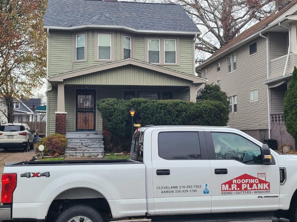 A white truck is parked in front of a house.