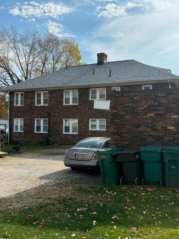 A car is parked in front of a brick building.