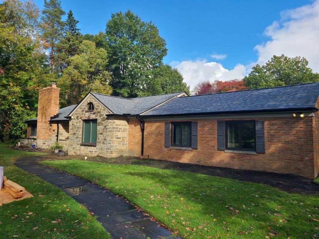 A large brick house with a driveway leading to it