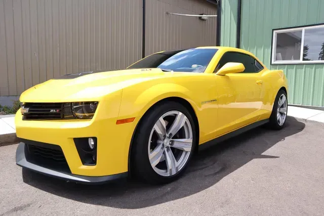 A yellow car is parked in front of a building