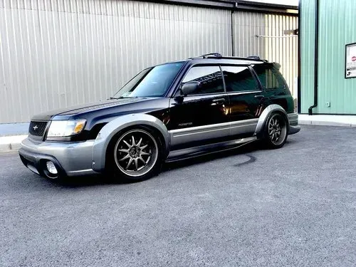 A black suv is parked in a parking lot in front of a building.