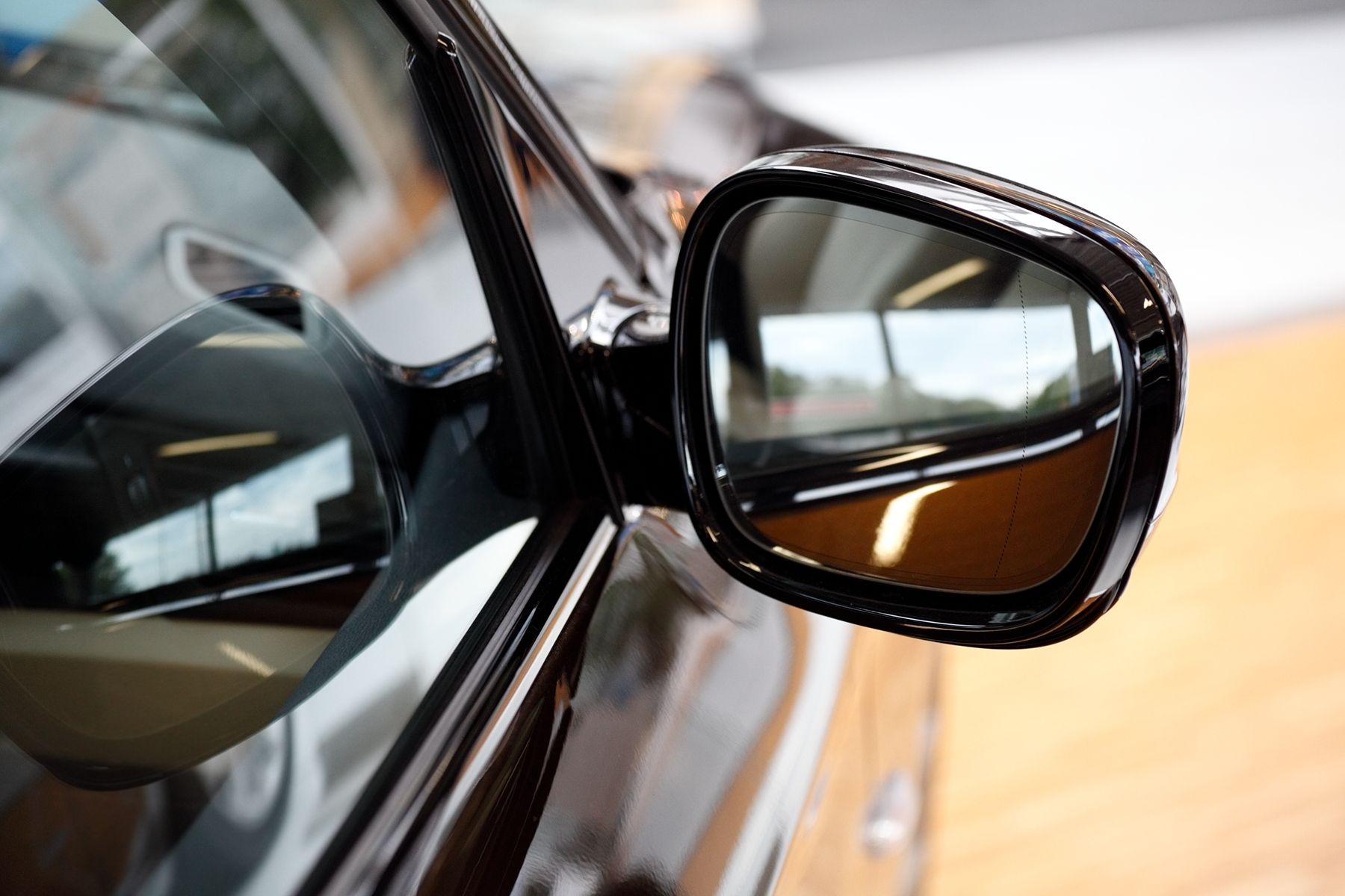 A black dodge charger is parked in front of a building.