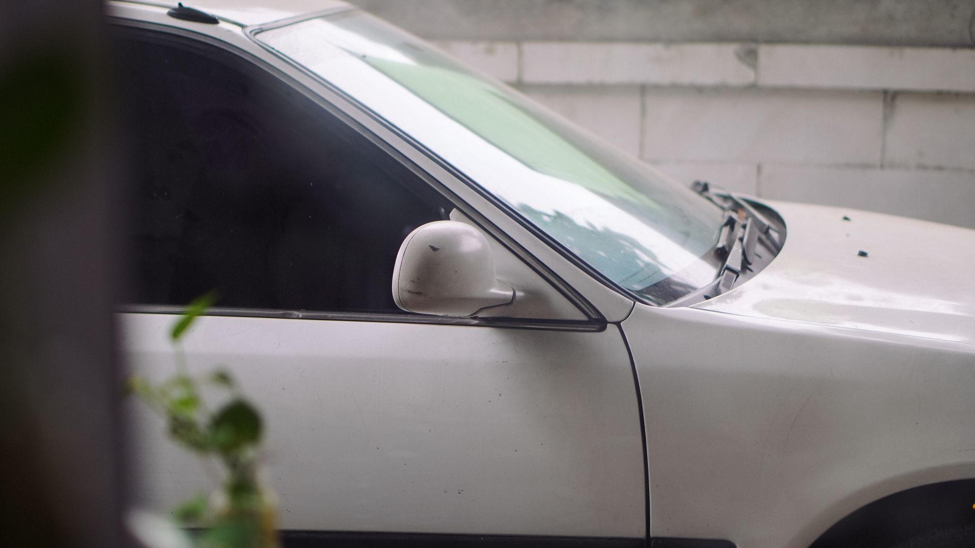A black dodge charger is parked in front of a building.