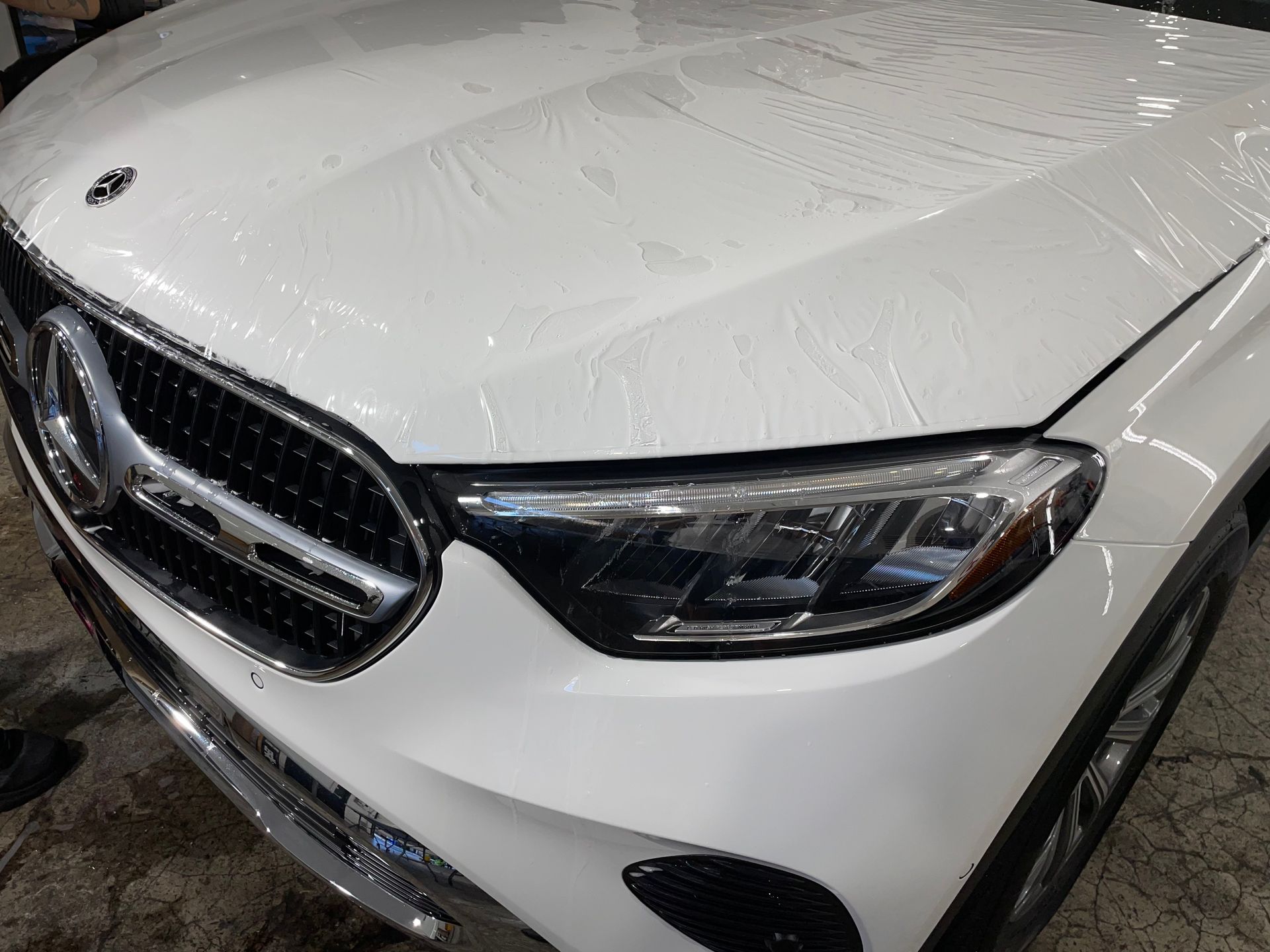 White Mercedes car hood covered in protective film, in a shop - West Salem, OR
