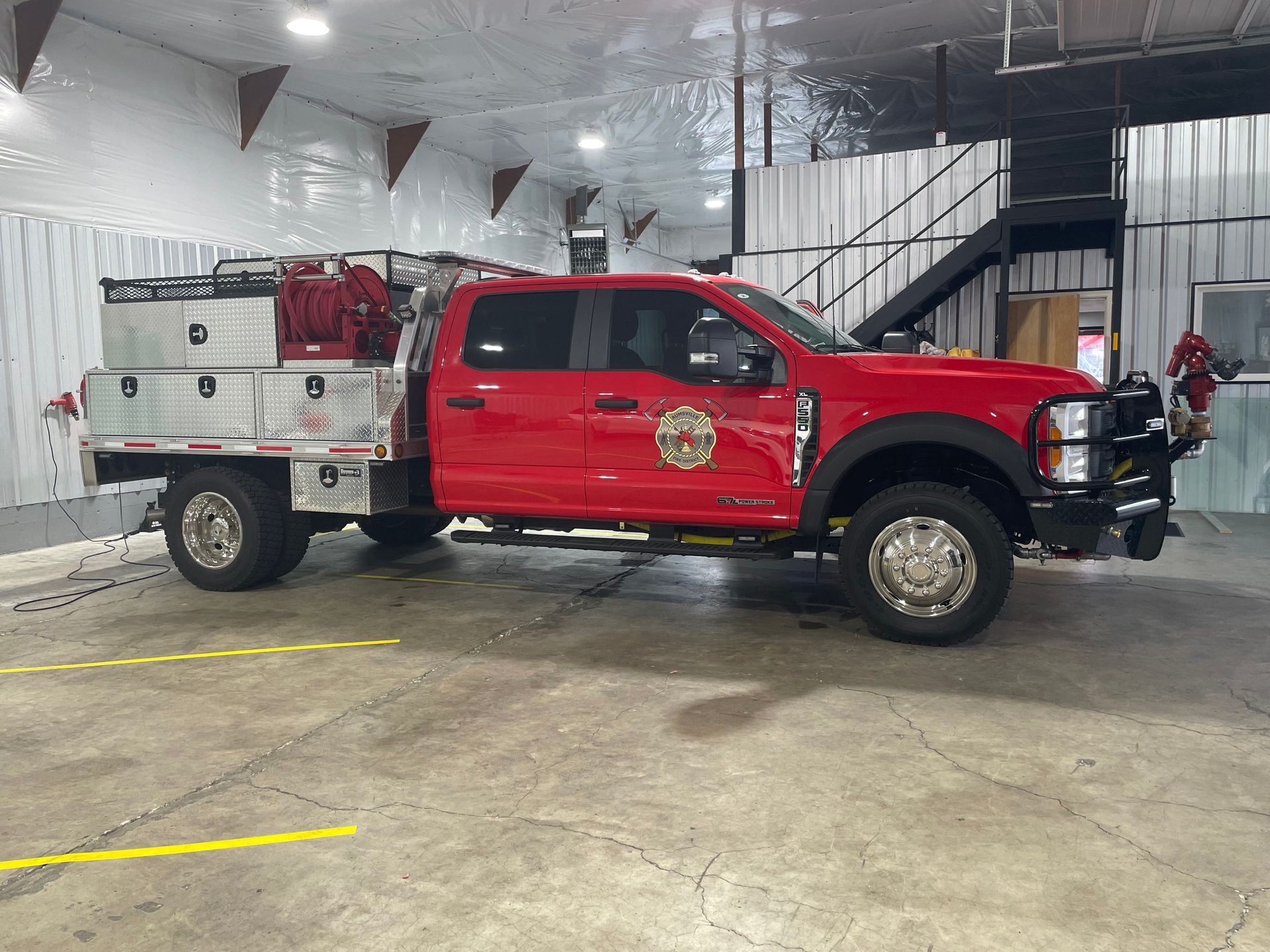Red fire service truck parked inside a facility, equipped with storage compartments and a front bumper guard from the Aumsville Fire Department of Oregon got installed heat-controlled films