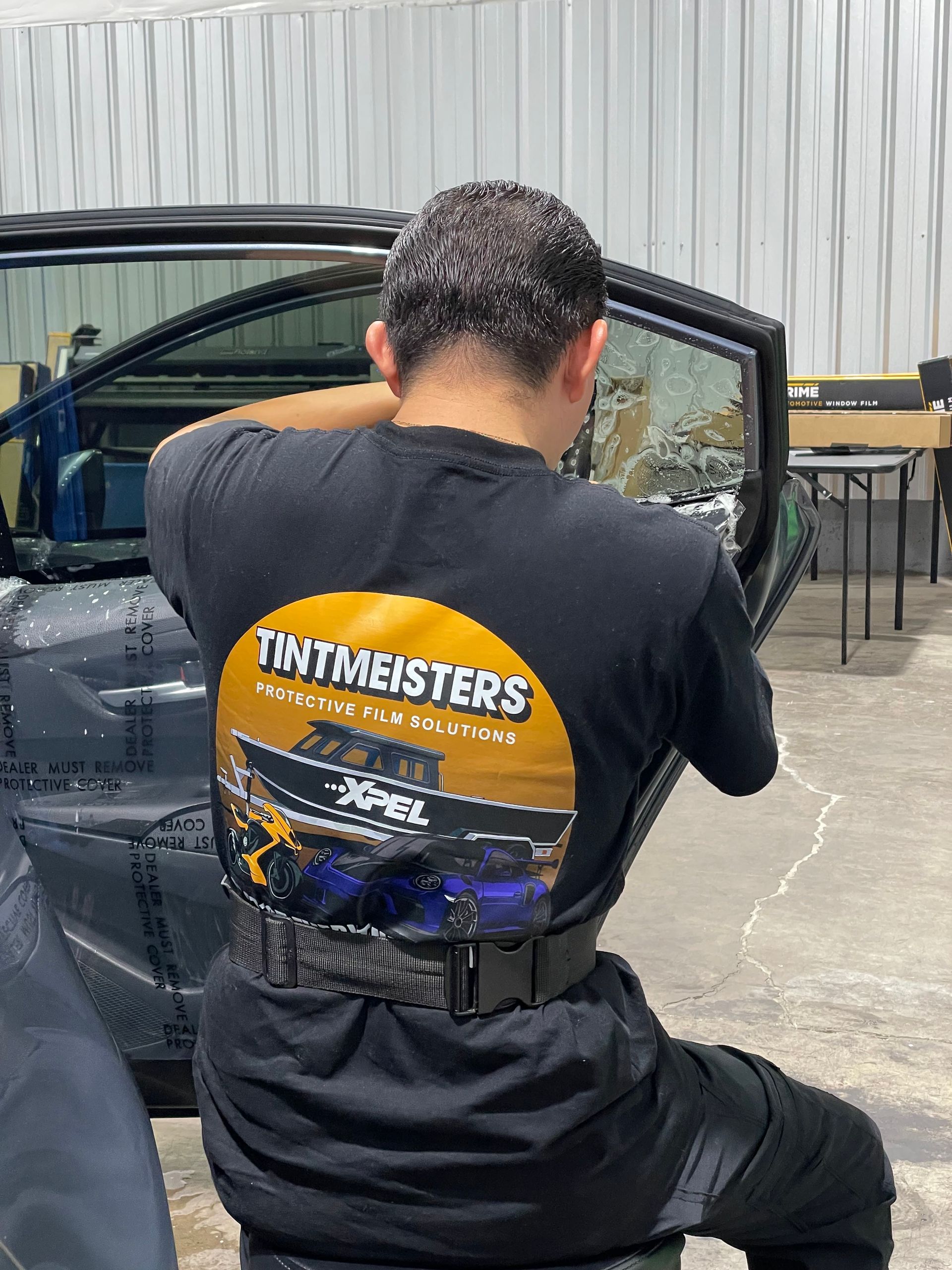 TINTMEISTERS staff in black shirt installing window tint on vehicle - Salem and Keizer Area