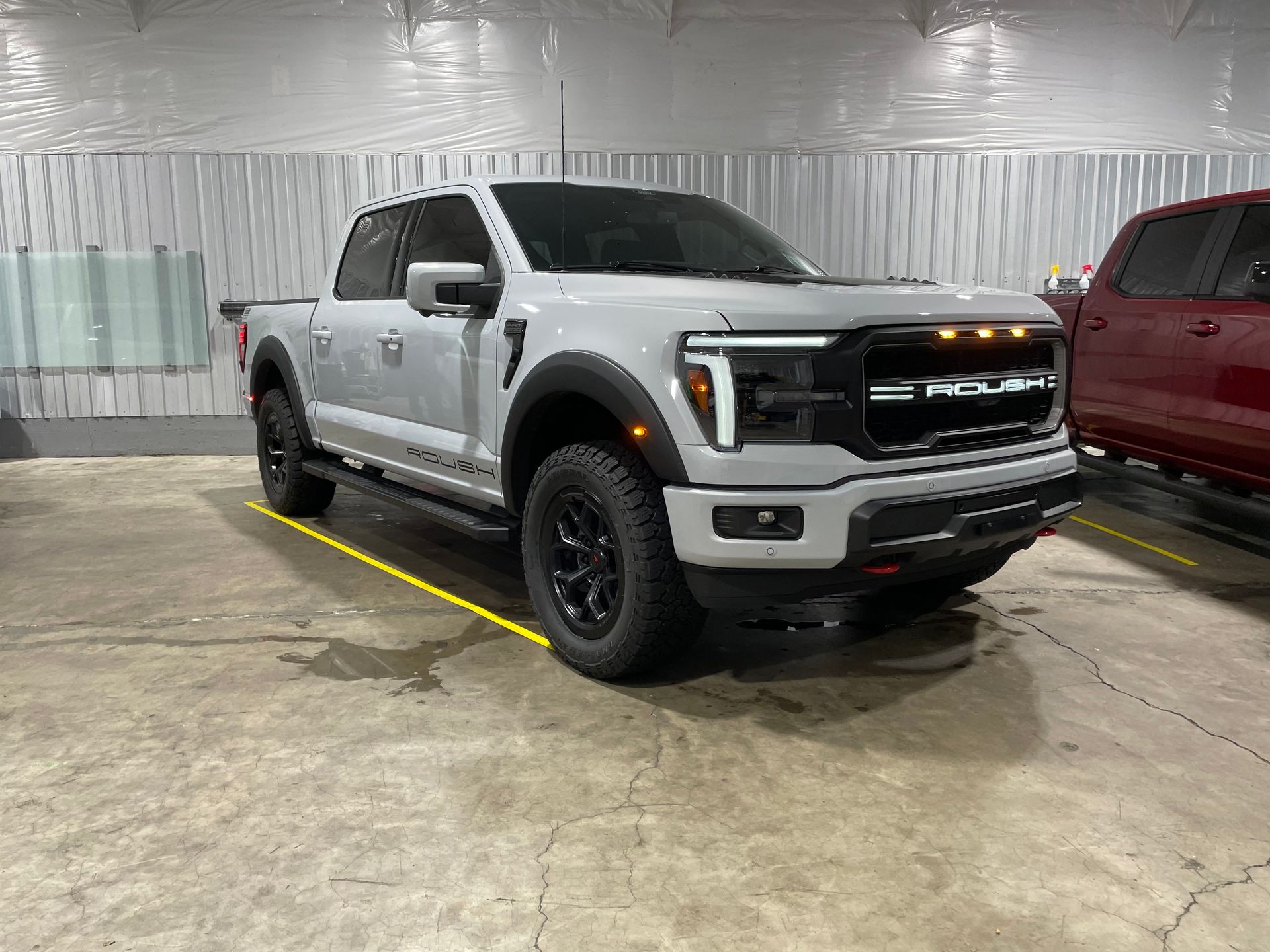 White Ford Roush pickup truck with privacy-tinted windows inside a garage - Independence, OR
