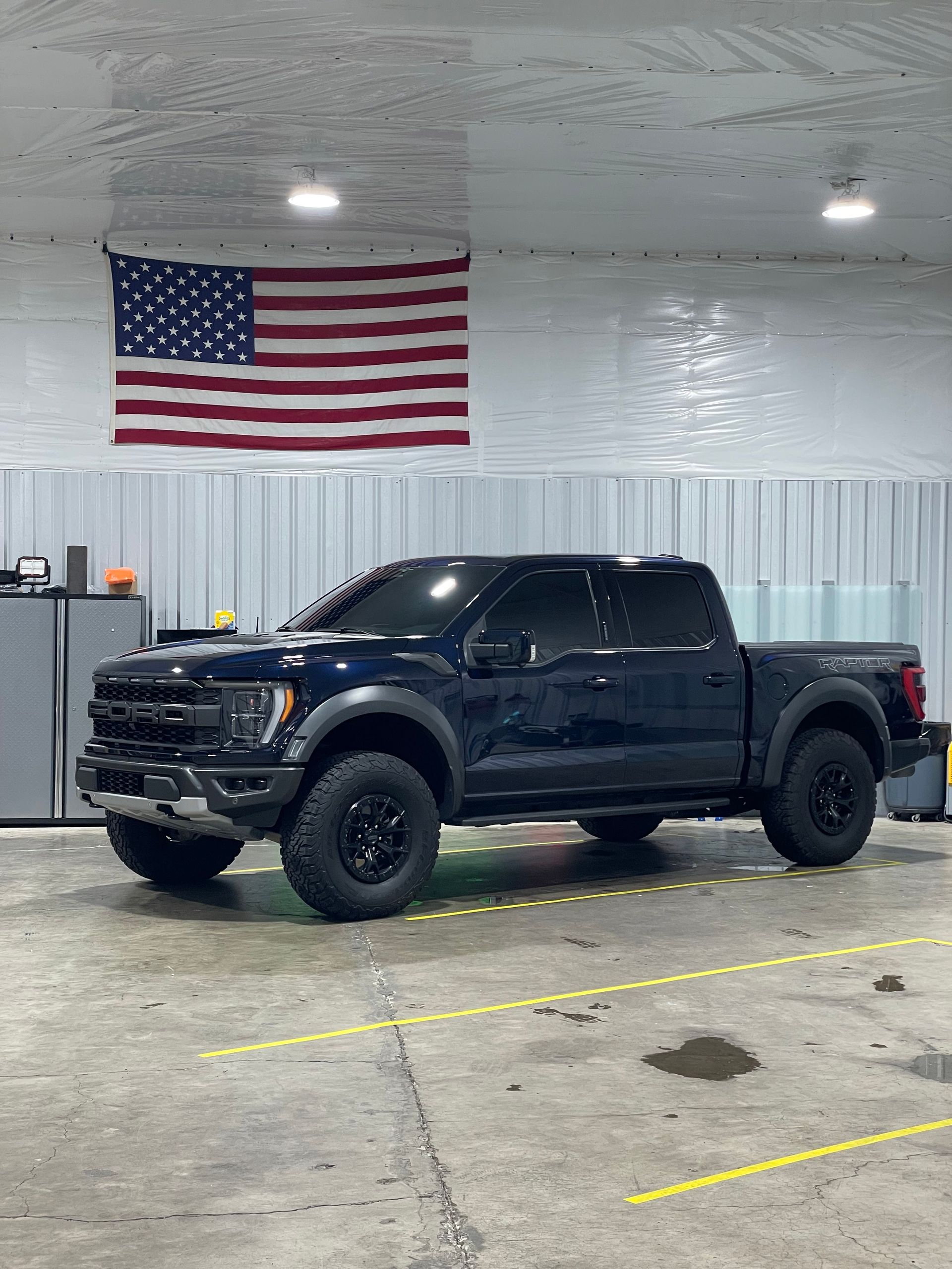 Dark blue Ford Raptor pickup truck  with tinted windows parked in a garage - Woodburn, OR