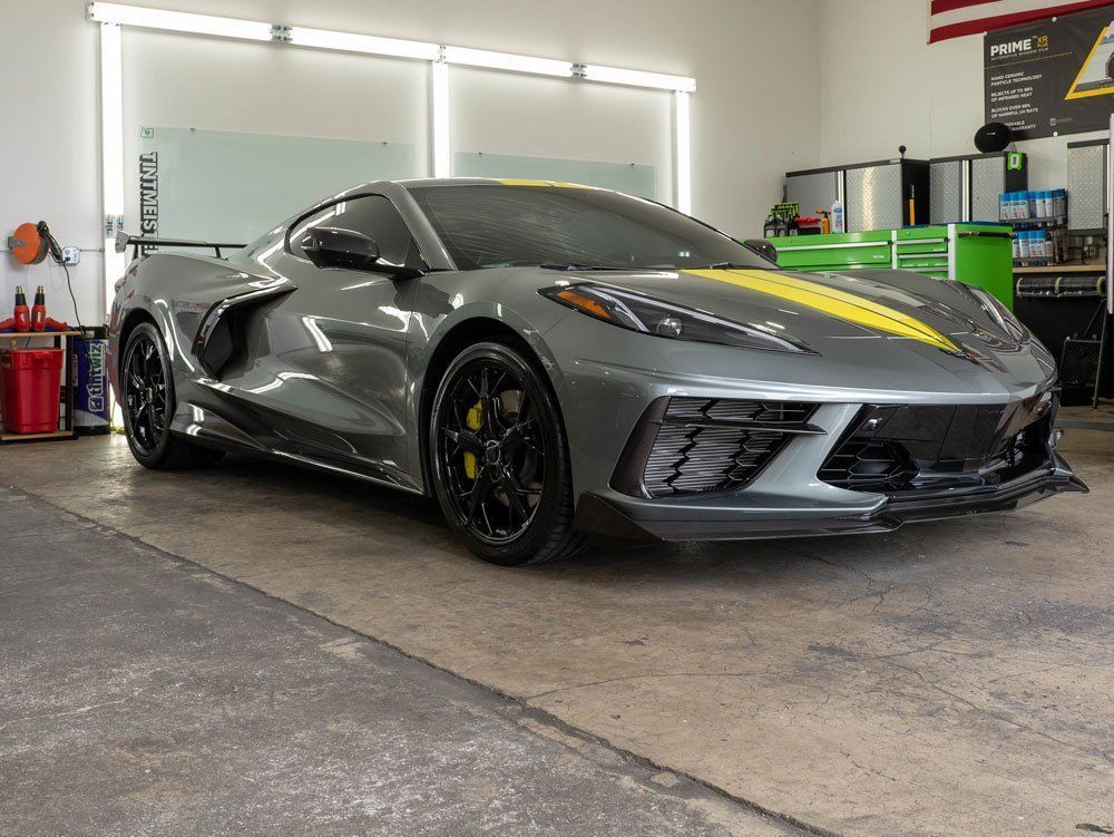 A gray corvette is parked in a garage.