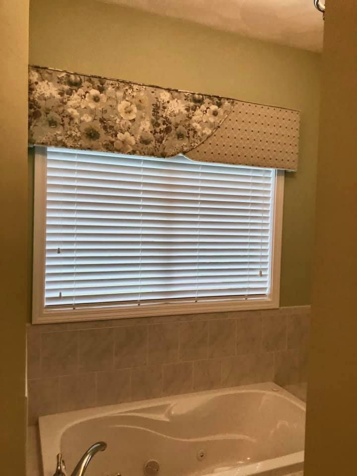 A window with blinds and curtains in a room